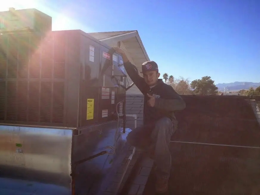 HVAC technician performing Air Duct Repair on a rooftop unit in Suffield